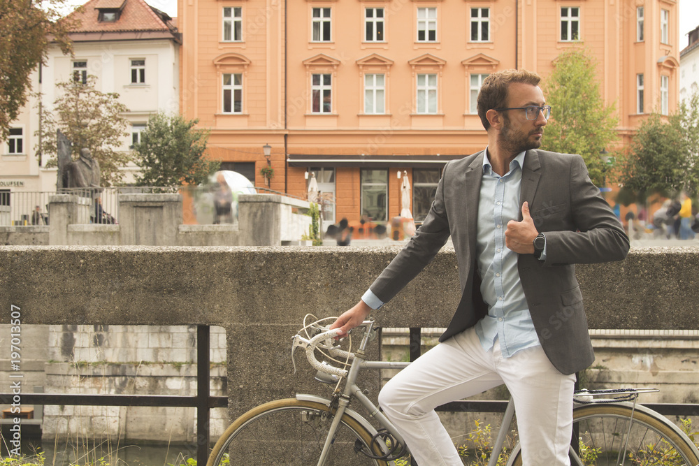 Modern business man standing with retro bicycle on the bridge.