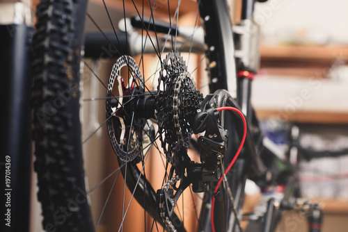 selective focus of bicycle wheel with chain in workshop