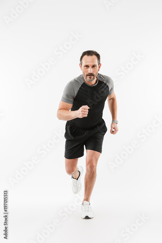 Handsome serious mature sportsman running isolated