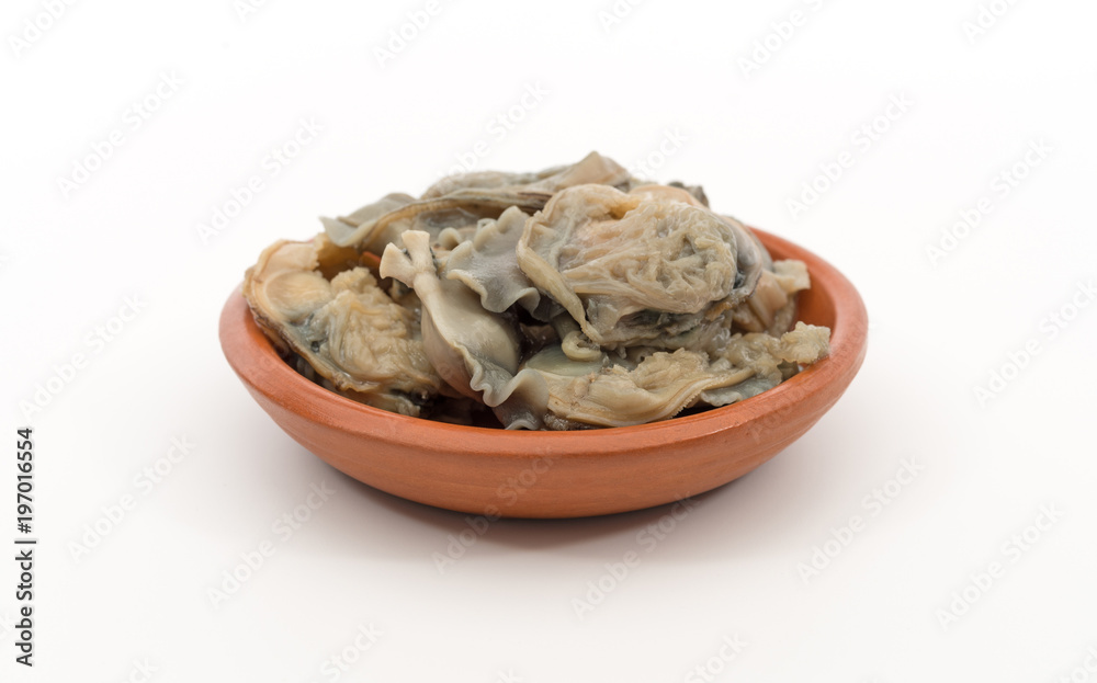 Side view of a small bowl filled with canned cherrystone clams on a white background. Side view of a small bowl filled with canned cherrystone clams on a white background.