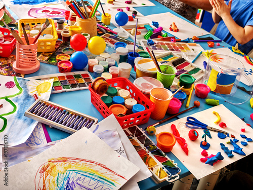 Group hands keeps brush painting on table in kindergarten. Art workshop for talented child. Good hobby for children. Preparatory courses in drawing for schoolchildren.