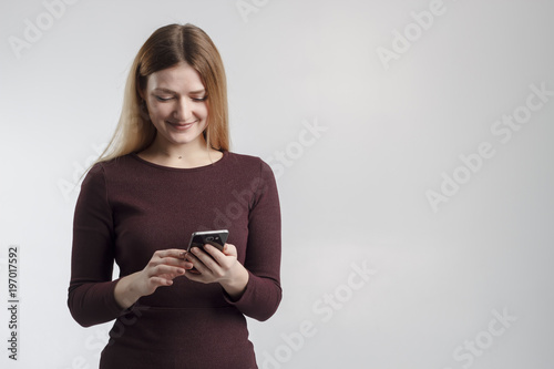 Surprised young female blogger chatting with best friends in social network on mobile phone while received shocking good news using wifi zone isolated on white background photo