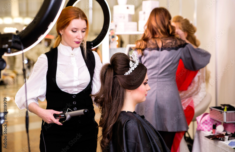 hairdresser makes models hairstyle at beauty pageant