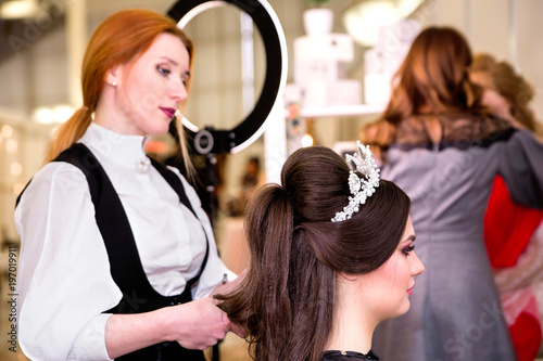 hairdresser makes models hairstyle at beauty pageant