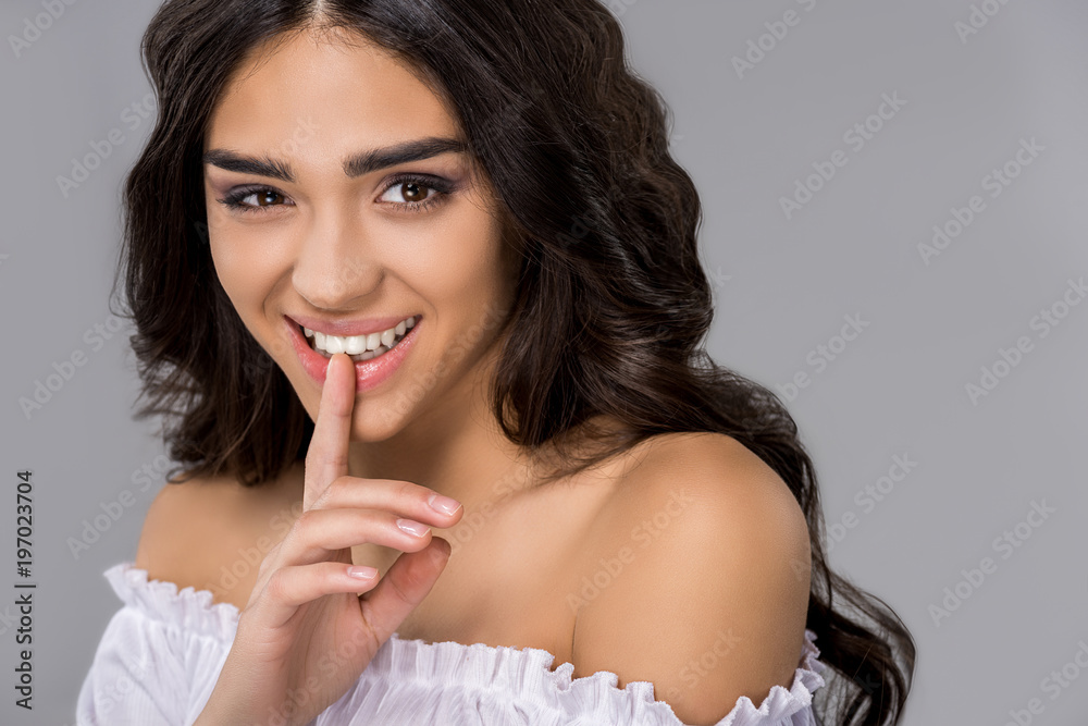 portrait of smiling tanned girl with silence symbol, isolated on grey portrait of smiling tanned girl with silence symbol, isolated on grey