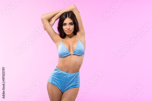 beautiful stylish girl posing in trendy blue bikini, isolated on pink