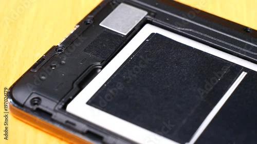 Male human hand putting battery into phone. Smartphone fixing, technology repairing concept.