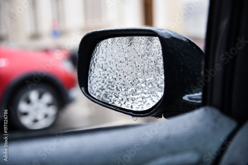 Vehicle mirror covered in ice during freezing rain © roibu