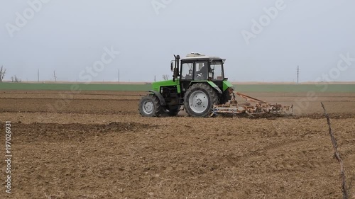 Lush and loosen the soil on the field before sowing. The tractor plows a field with a plow.