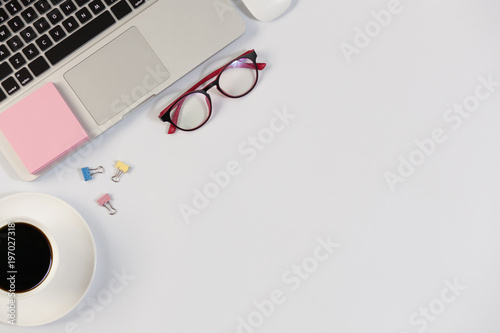 White Office desk table with laptop,smartphone and coffee cup and accessories. Business desk with a keyboard, mouse and pen on white table. Top view of workplace