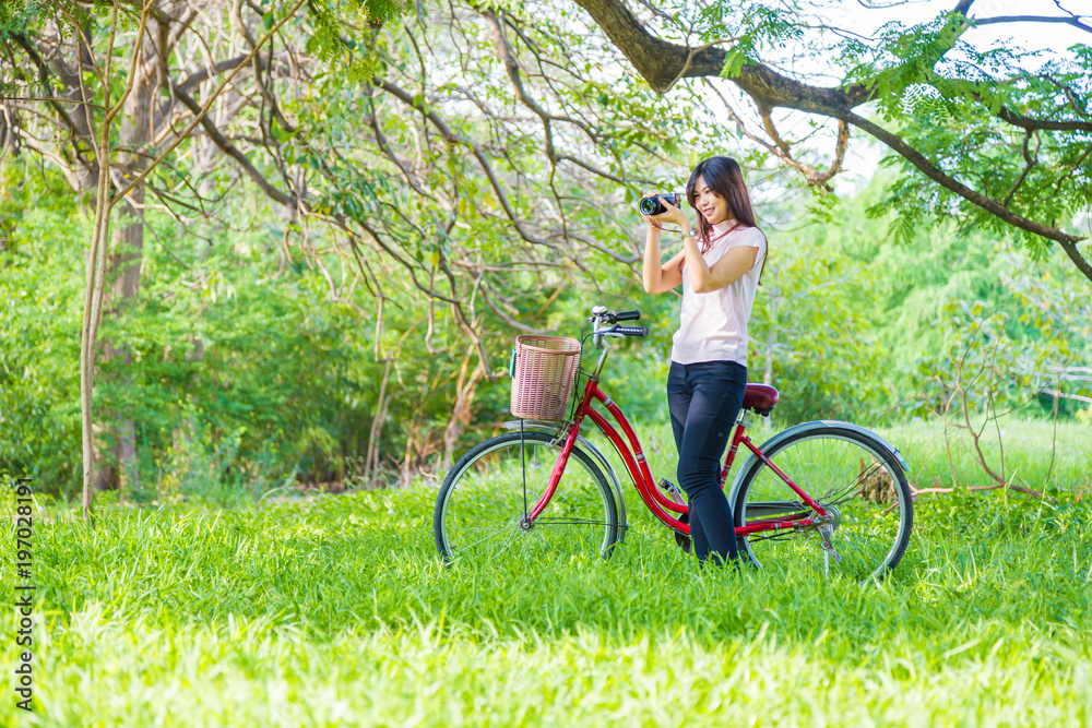 Obraz premium Beautiful women leisure in park with red bike
