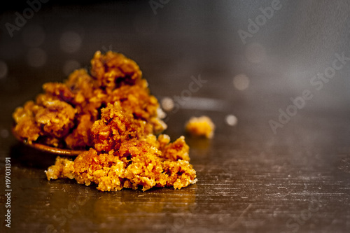 Close up of an bowl or plate full of organic jaggery on a wooden surface in Dark Gothic colors. photo