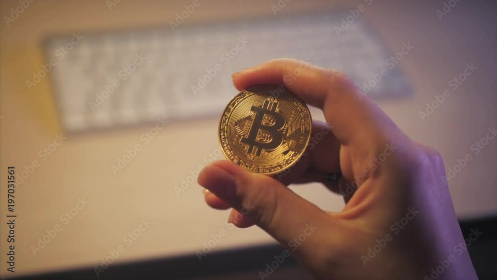 bitcoin in the hands on the keyboard background bitcoin in the hands on the keyboard background