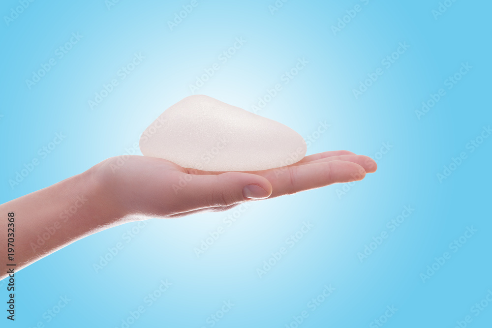 Silicone breast implant on hands . Silicone breast implant on hands .