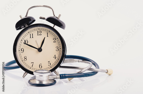 stayhealthy concept, stethoscope and alarm clock on white background photo