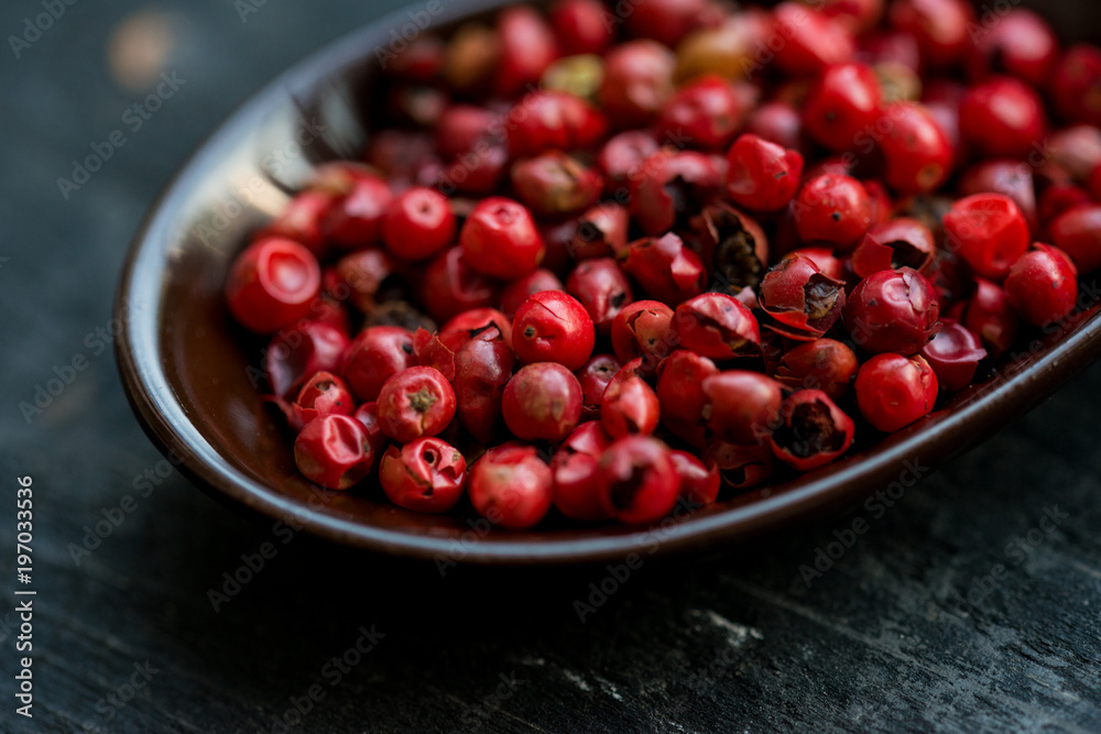 Close up pink peppercorn in spoon dark background Close up pink peppercorn in spoon dark background