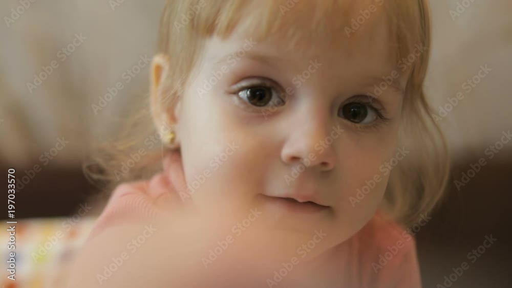 Beautiful two years old girl draws by paintbrush on the camera lens. Cute blonde child. Brown eyes. Close up Beautiful two years old girl draws by paintbrush on the camera lens. Cute blonde child. Brown eyes. Close up