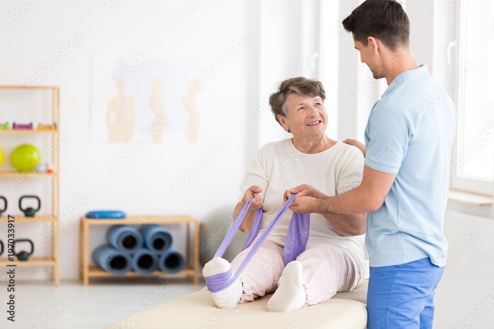 Obraz premium Elderly woman exercising with band
