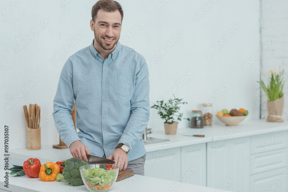 portrait of smiling man cooking salad in kitchen at home portrait of smiling man cooking salad in kitchen at home