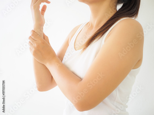 Close up young woman holding her wrist symptomatic Office Syndrome. Healthcare and arm pain concept.