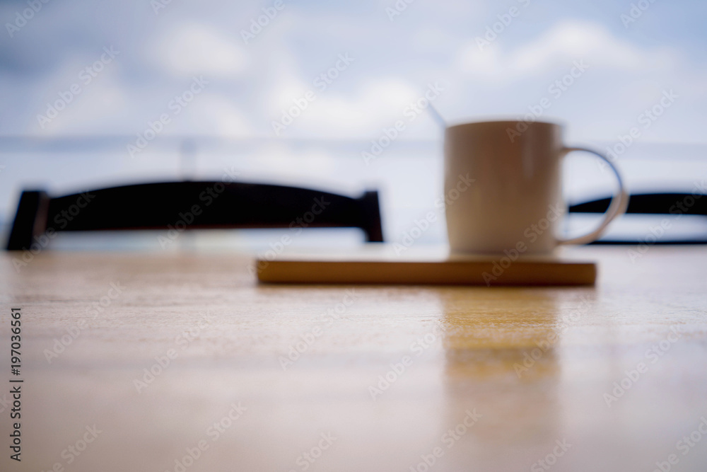 a coffee cup with blur put on table. a coffee cup with blur put on table.
