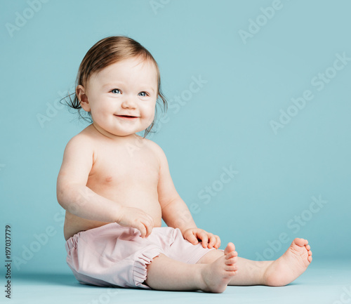 Smiling little girl sitting on the floor