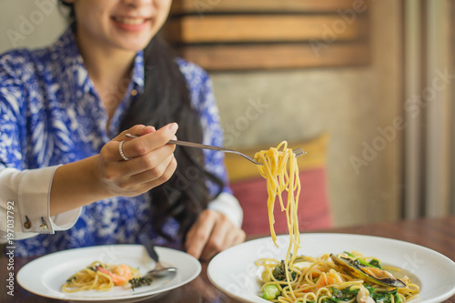 Spaghetti on a fork. Girl keeping fork with spaghetti.  Young woman eating Italian pasta.