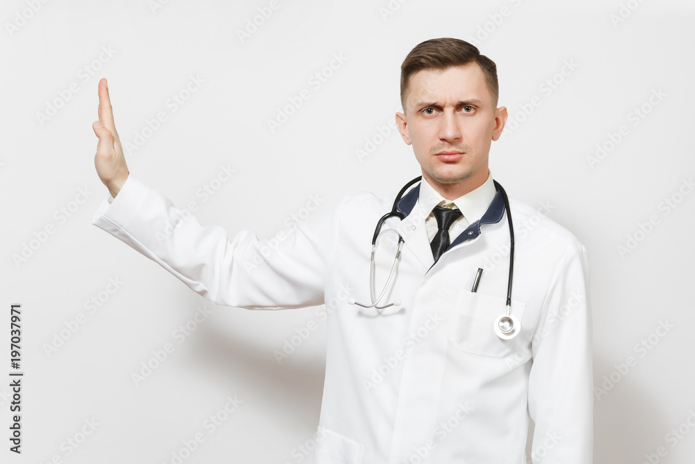 Serious young doctor man isolated on white background. Male doctor in medical uniform, stethoscope looking camera, showing stop gesture with palm aside. Healthcare personnel health medicine concept. Serious young doctor man isolated on white background. Male doctor in medical uniform, stethoscope looking camera, showing stop gesture with palm aside. Healthcare personnel health medicine concept.