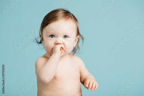 Little girl putting her hand into her mouth.