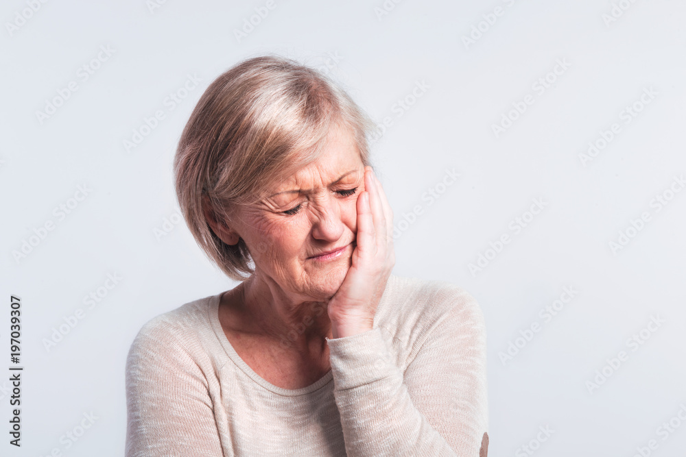 Studio portrait of a senior woman in pain. Studio portrait of a senior woman in pain.