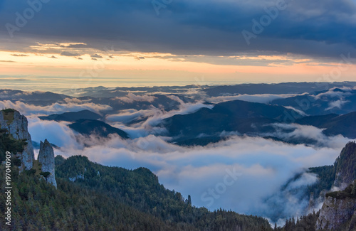 Beautiful mountain view with fog over the peaks at sunrise, Ceahlau massif, Eastern Carpathians, Moldova, Romania