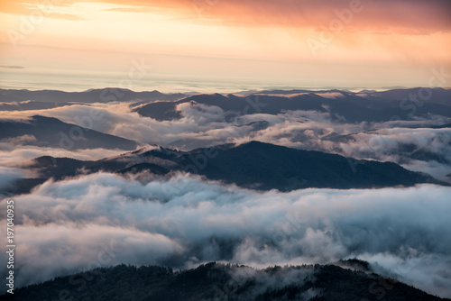 Beautiful mountain view with fog over the peaks at sunrise  Ceahlau massif  Eastern Carpathians  Moldova  Romania
