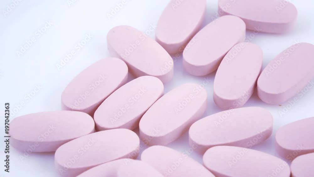 Oval pink tablets on plate Oval pink tablets on plate