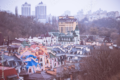 City of Kyiv (Kiev), capital of Ukraine, panorama. Colorful houses of Vozdvizhenka (Vozdvizhenska) elite district. Kitsch. Cloudy spring afternoon. Wet rooftops. Vintage colors photo