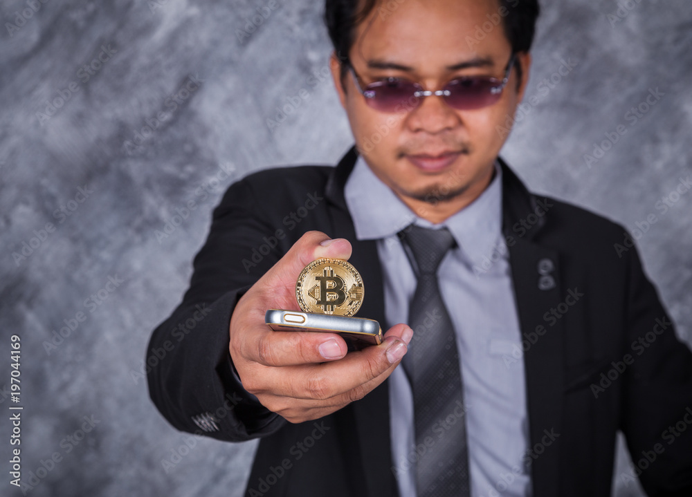 business man with bitcoin and using mobile phone