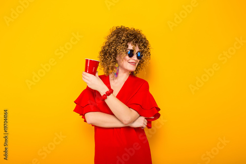 Attractive woman with short curly hair and drink