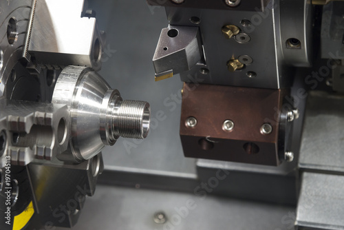 The CNC lathe machine cutting the thread at the cone shape part.