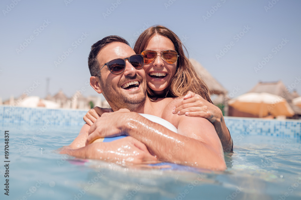 Young couple at the swimming pool enjoying together