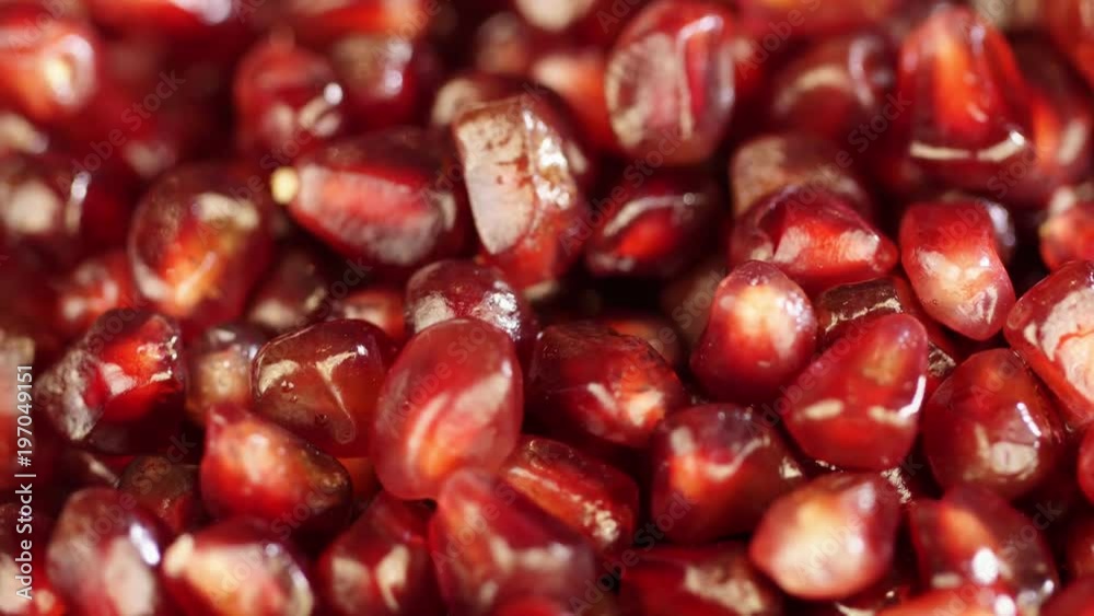 Bright juicy pomegranate. Pomegranate grains on a white background. Macro. macro shooting. Seeds of pomegranate turn in a shot. Red grains of pomegranate close up. Bright juicy pomegranate. Pomegranate grains on a white background. Macro. macro shooting. Seeds of pomegranate turn in a shot. Red grains of pomegranate close up.