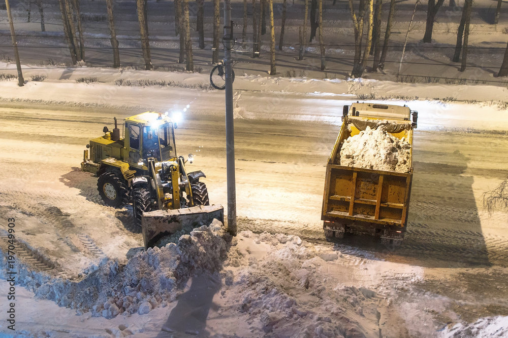 loader removes snow in the night