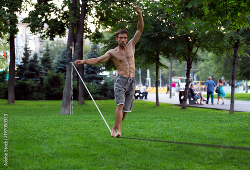 Slackline in the summer park Against the background of city bustle photo
