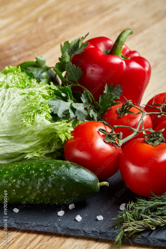 Organic closeup still life of assorted fresh vegetables and herbs on rustic wooden background, topview, selective focus.