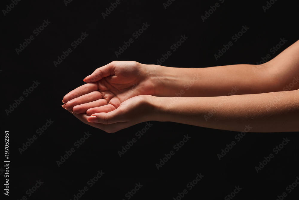 Woman keeping hands in cupped shape, cutout on black