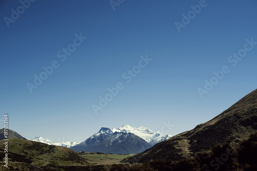 Paisaje de picos de montañas nevadas con cielo azul despejado en Nueva Zelanda