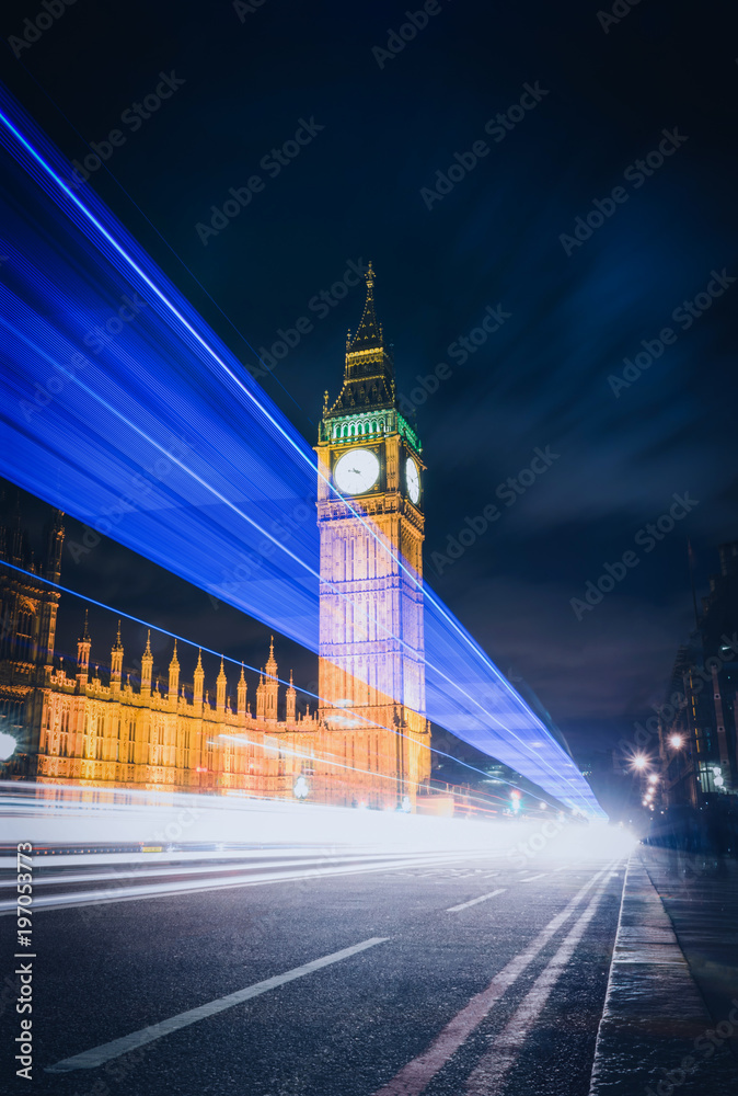Big Ben at night with the lights of the cars in London city, UK.