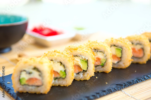 Homemade sushi with salmon, omelet, cucumber and soft cheese. Rustic style photo