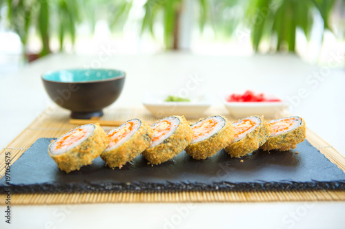 Sushi rolls on black slate surface. Japanese food. Hot fried Sushi Roll photo