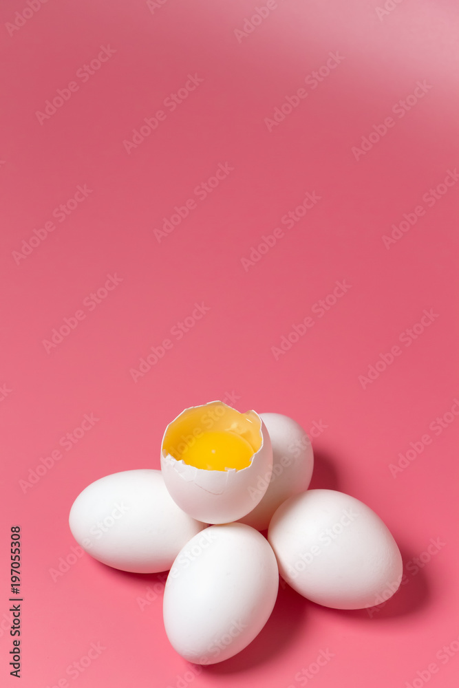 Fresh farm chicken eggs, food background. Cracked egg with white and yolk over pink. Spring easter theme. Close up. Copy space.