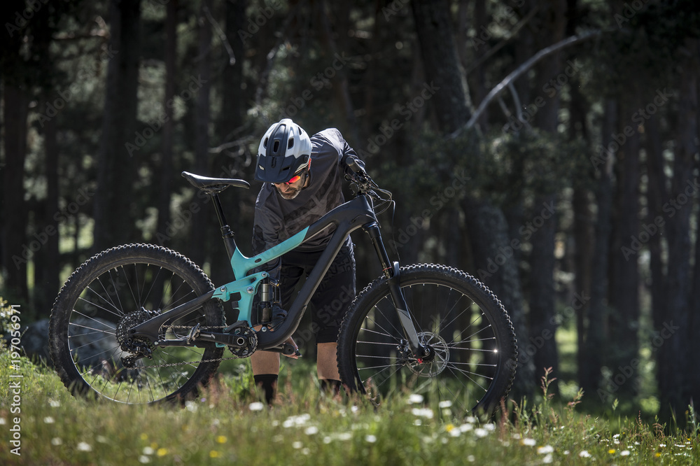 biker getting ready to ride in the forest biker getting ready to ride in the forest