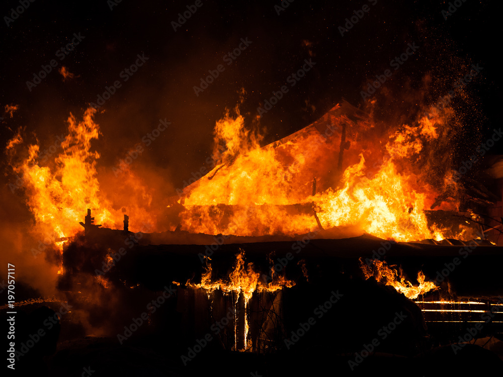 Burning fire flame on wooden house roof Burning fire flame on wooden house roof
